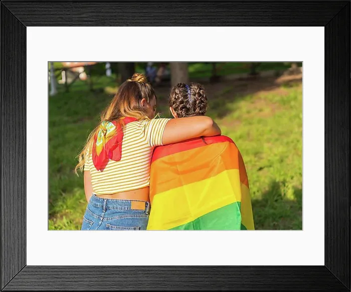Framed Print : A closeup shot of two young Caucasian females holding LGBT pride flag outdoors