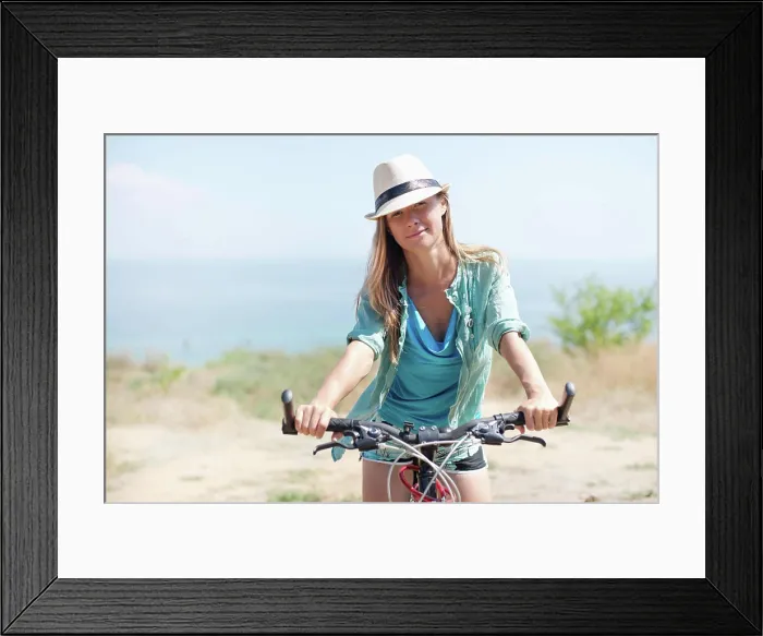 Framed Print : Attractive woman with bike Attractive woman with bike at the sea