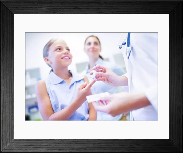 Framed Print : Doctor giving girl a finger prick test