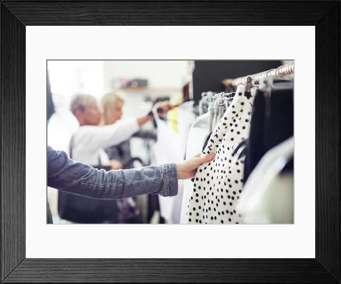 Framed Print : Shopping for the perfect outfit among racks of clothes Framed Print : Shopping for the perfect outfit among racks of clothes