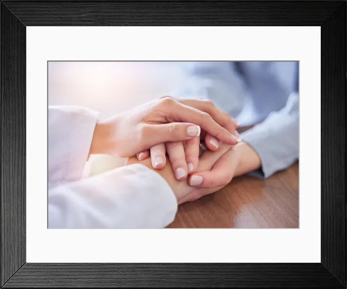 Framed Print : Holding hands, doctor and patient at desk for comfort