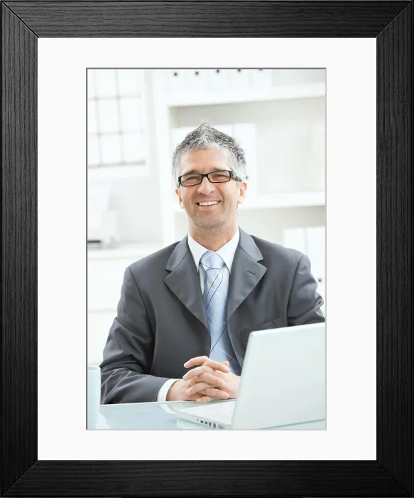 Framed Print : Businessman thinking Businessman sitting at office desk working on laptop computer