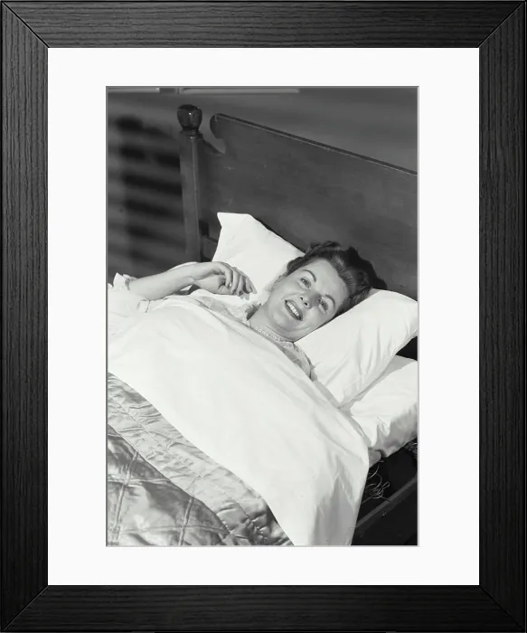 Framed Print : Vintage Photograph. Woman lying in bed smiling Framed Print : Vintage Photograph. Woman lying in bed smiling