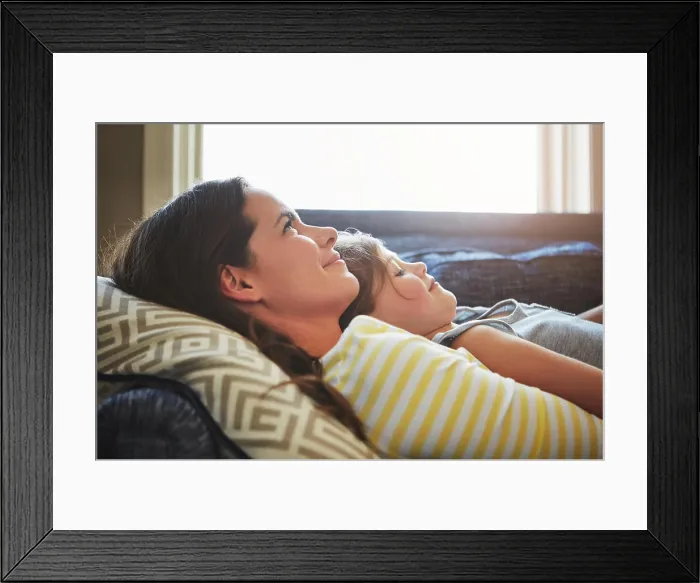 Framed Print : Love, rest and mother cuddle her child while relaxing on sofa in the living room of their home Framed Print : Love, rest and mother cuddle her child while relaxing on sofa in the living room of their home