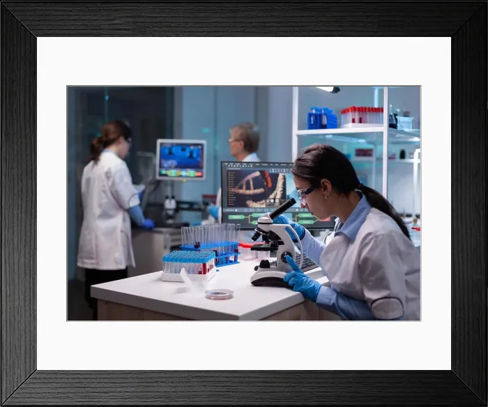 Framed Print : Biochemist scientists studying reaction of virus on microscope in laboratory