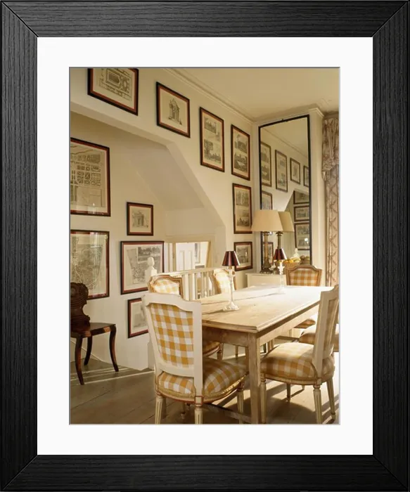 Framed Print : Neutral-checked upholstered chairs and simple wood table in small dining room with tall mirror