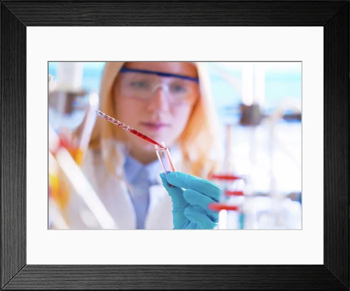 Framed Print : Female lab technician dripping chemical into test tube with pipette Framed Print : Female lab technician dripping chemical into test tube with pipette