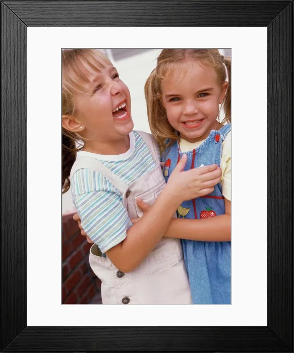 Framed Print : Close-up of two girls hugging each other