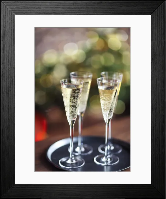 Framed Print : Champagne glasses on lights background. Christmas celebration background Framed Print : Champagne glasses on lights background. Christmas celebration background