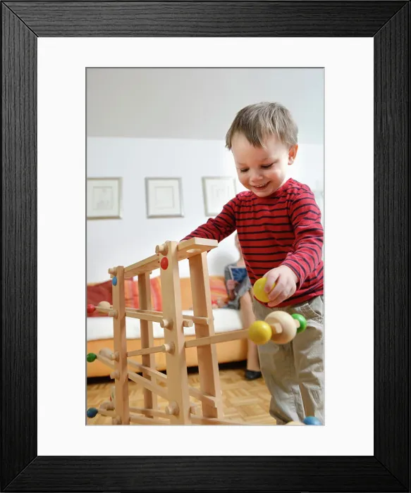 Framed Print : Boy playing skill game, smiling Framed Print : Boy playing skill game, smiling