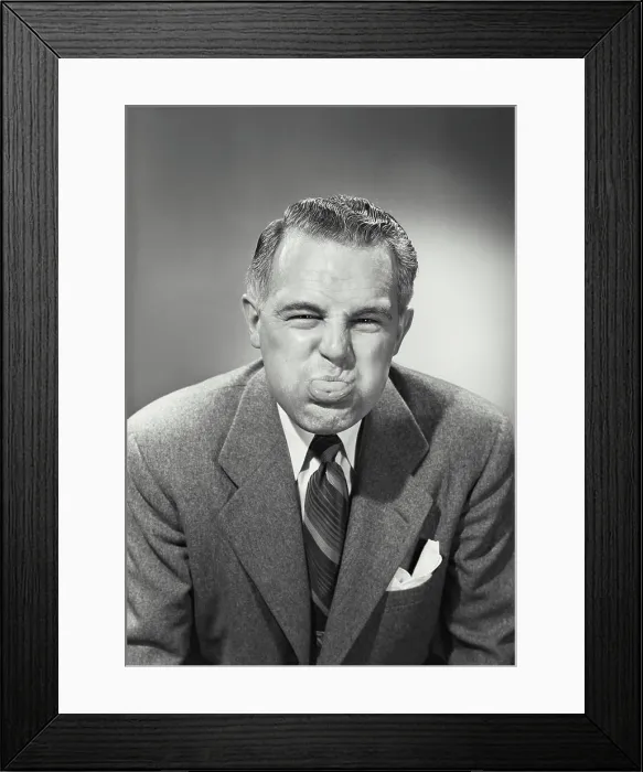 Framed Print : Vintage photograph. Close-up of a businessman blowing raspberry