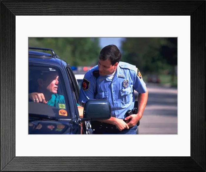 Framed Print : Police officer approaches the driver of a car after stopping him for a traffic violation Framed Print : Police officer approaches the driver of a car after stopping him for a traffic violation