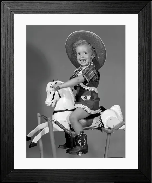Framed Print : 1950S Girl Dressed As Cowgirl Riding Rocking Horse Framed Print : 1950S Girl Dressed As Cowgirl Riding Rocking Horse