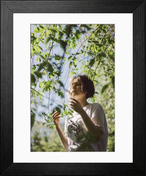 Framed Print : Portrait of a young girl with closed eyes under the sun under a tree Framed Print : Portrait of a young girl with closed eyes under the sun under a tree