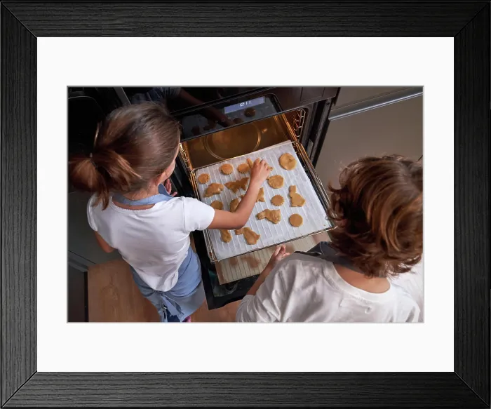 Framed Print : From above of faceless children in aprons spreading cookies on cookie sheet in oven at modern kitchen Framed Print : From above of faceless children in aprons spreading cookies on cookie sheet in oven at modern kitchen