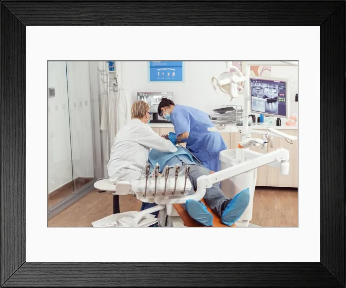 Framed Print : Senior dentist doctor and nurse preparing patient for removing crowns