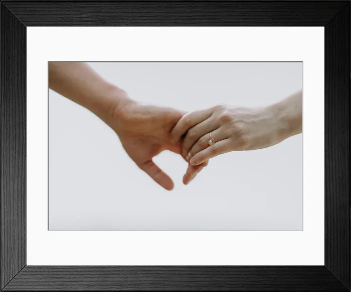 Framed Print : A couple holding hands with a gold engagement ring against a light sky Framed Print : A couple holding hands with a gold engagement ring against a light sky