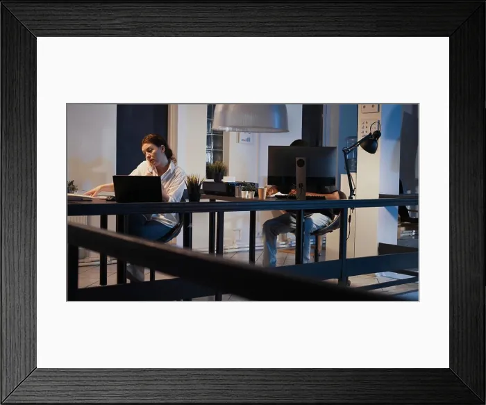 Framed Print : Executive manager working on laptop and answering landline phone call Framed Print : Executive manager working on laptop and answering landline phone call