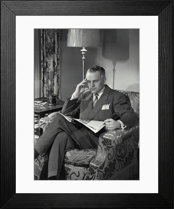 Framed Print : Vintage photograph. Man in suit and tie sitting and reading paper Framed Print : Vintage photograph. Man in suit and tie sitting and reading paper