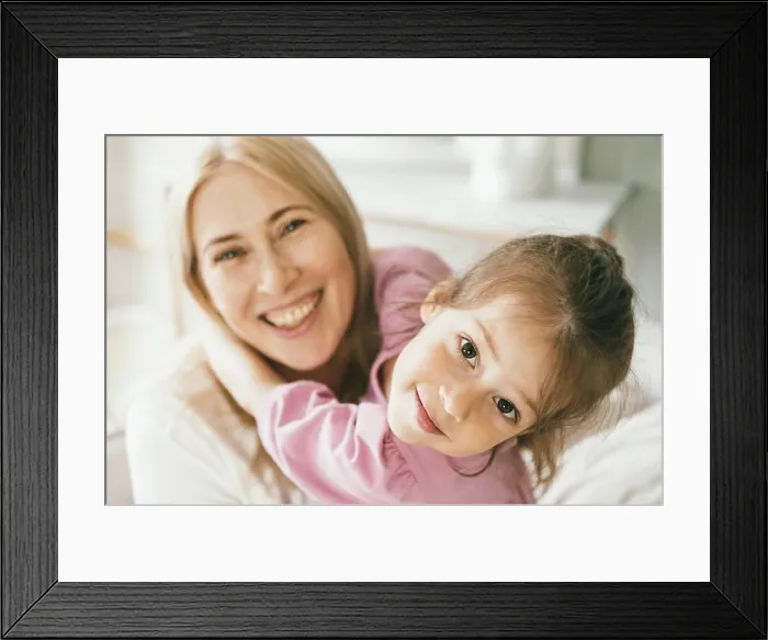Framed Print : A little girl hugs his mother. The granddaughter hugs her grandmother Framed Print : A little girl hugs his mother. The granddaughter hugs her grandmother