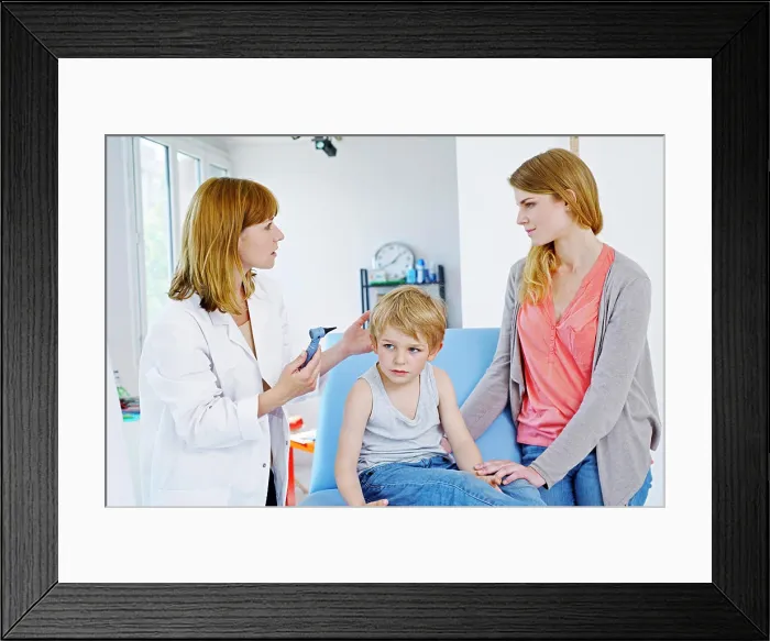 Framed Print : Doctor examining a child's ear