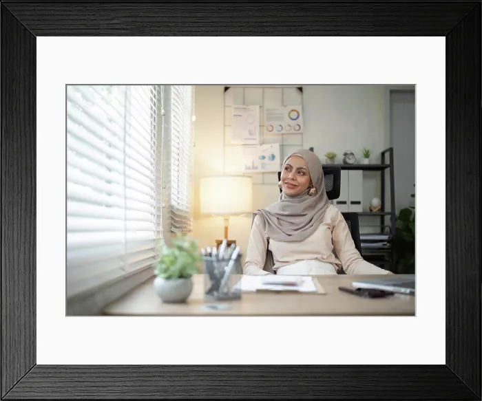 Framed Print : Smiling Muslim woman sitting at office desk Framed Print : Smiling Muslim woman sitting at office desk