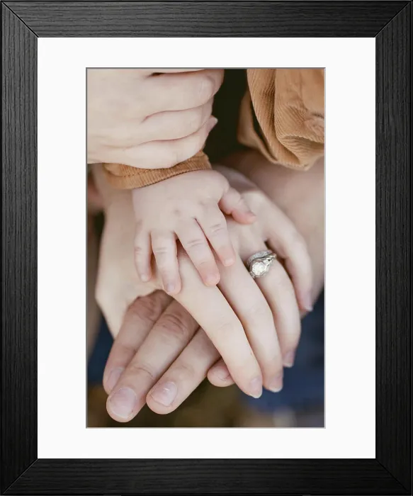Framed Print : Close-up of baby hand resting on parents hands with wedding ring
