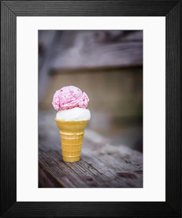 Framed Print : A scoop of coconut and a scoop of strawberry ice cream in an ice cream cone on a wooden table Framed Print : A scoop of coconut and a scoop of strawberry ice cream in an ice cream cone on a wooden table