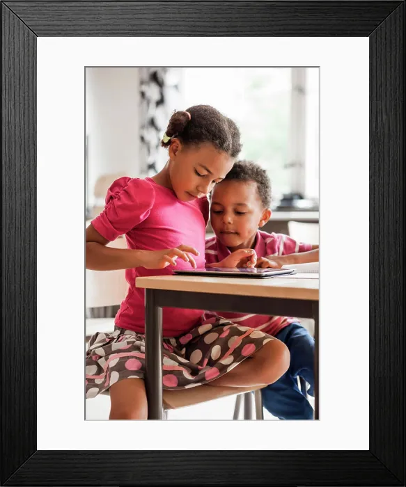 Framed Print : Siblings sharing a moment of discovery with a tablet at the kitchen table Framed Print : Siblings sharing a moment of discovery with a tablet at the kitchen table