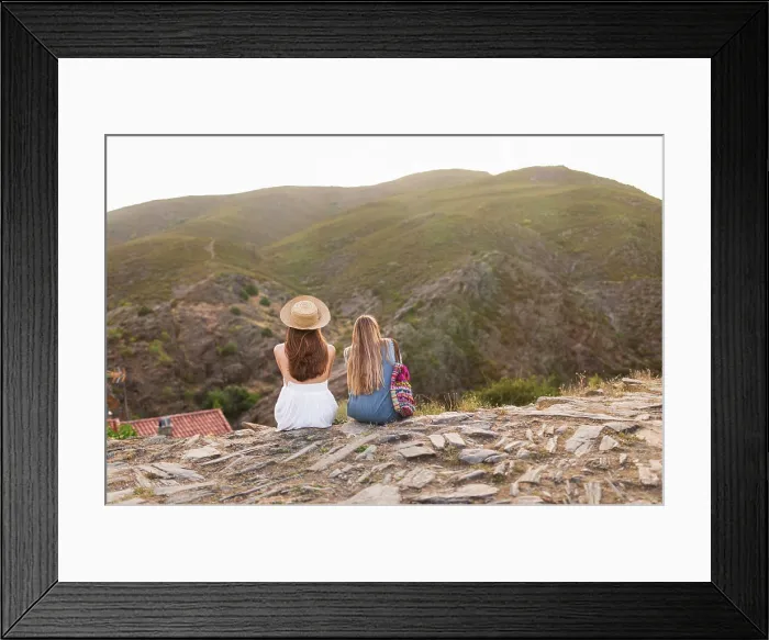 Framed Print : Back view of two tourists women sitting together on mountain edge Framed Print : Back view of two tourists women sitting together on mountain edge