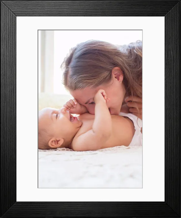 Framed Print : Mother blowing raspberries on baby's stomach, London, UK Framed Print : Mother blowing raspberries on baby's stomach, London, UK