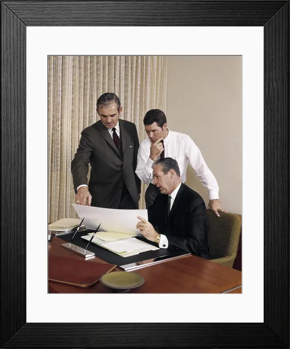 Framed Print : 1960s THREE EXECUTIVE MEN MEETING DISCUSSING PAPERWORK PLANS