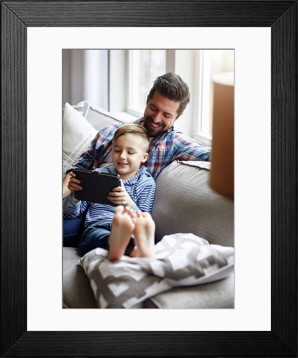 Framed Print : Dad, boy and house on couch with tablet Framed Print : Dad, boy and house on couch with tablet