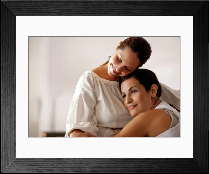 Framed Print : Mid-adult lesbian couple intimately relaxing together