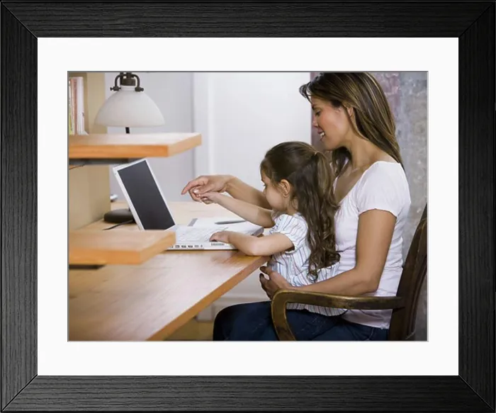 Framed Print : Mother and young daughter working on laptop computer Framed Print : Mother and young daughter working on laptop computer