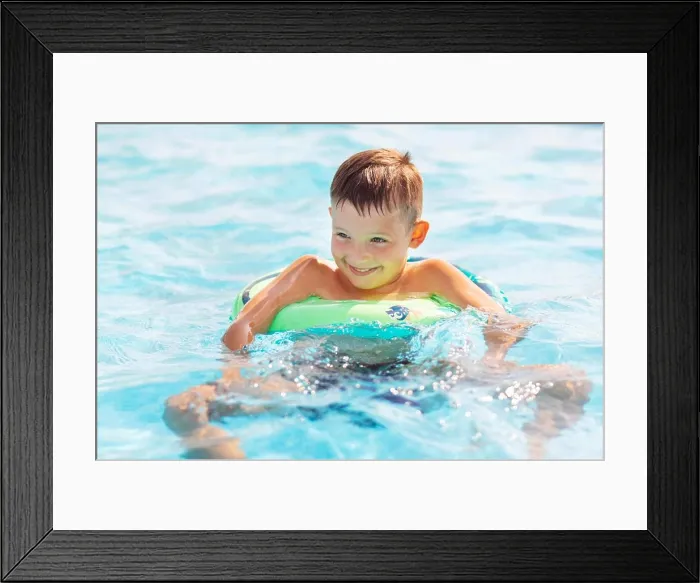 Framed Print : Funny happy child boy in swimming pool on inflatable rubber circle ring