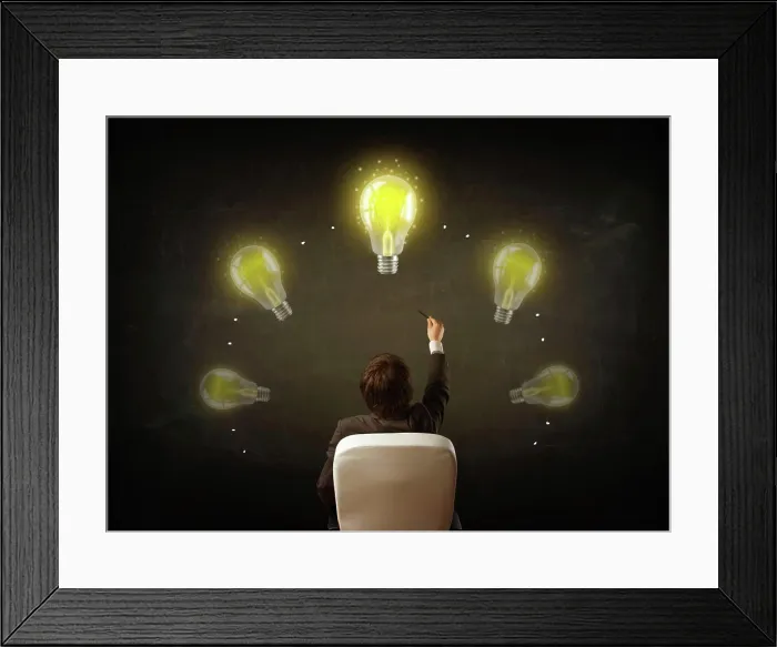 Framed Print : Geschäftsmann sitzt mit Lichtböcken über seinem Kopf Young businessman sitting in office chair in front of a balckboard Framed Print : Geschäftsmann sitzt mit Lichtböcken über seinem Kopf Young businessman sitting in office chair in front of a balckboard
