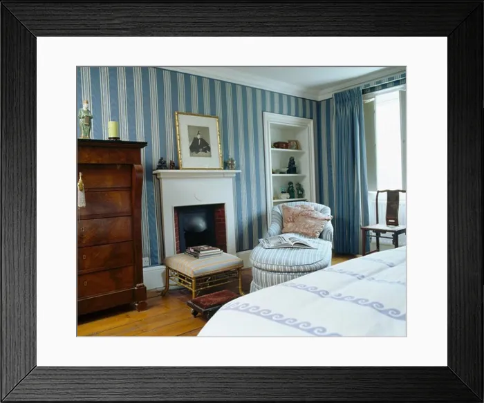 Framed Print : Blue striped wallpaper in townhouse bedroom with chaiselongue beside fireplace