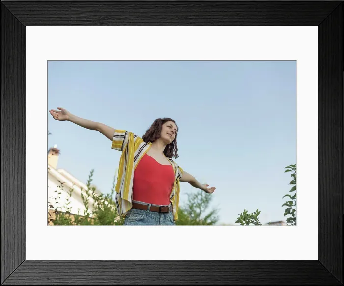 Framed Print : Carefree woman with arms outstretched in back yard Framed Print : Carefree woman with arms outstretched in back yard