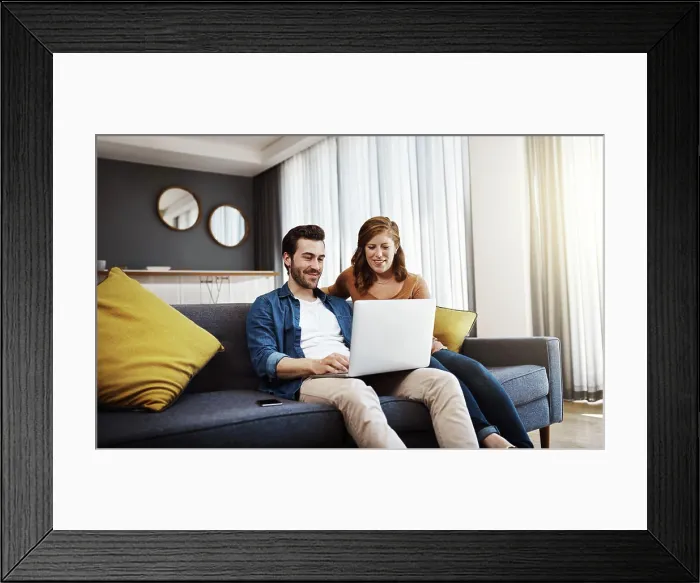 Framed Print : Home, smile and couple with laptop on sofa for online travel booking Framed Print : Home, smile and couple with laptop on sofa for online travel booking
