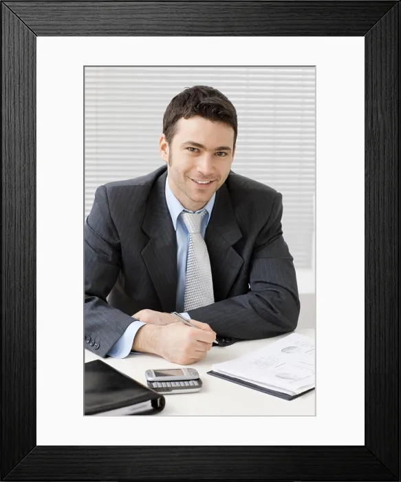 Framed Print : Businessman working at desk Happy young businessman working at desk at office Framed Print : Businessman working at desk Happy young businessman working at desk at office