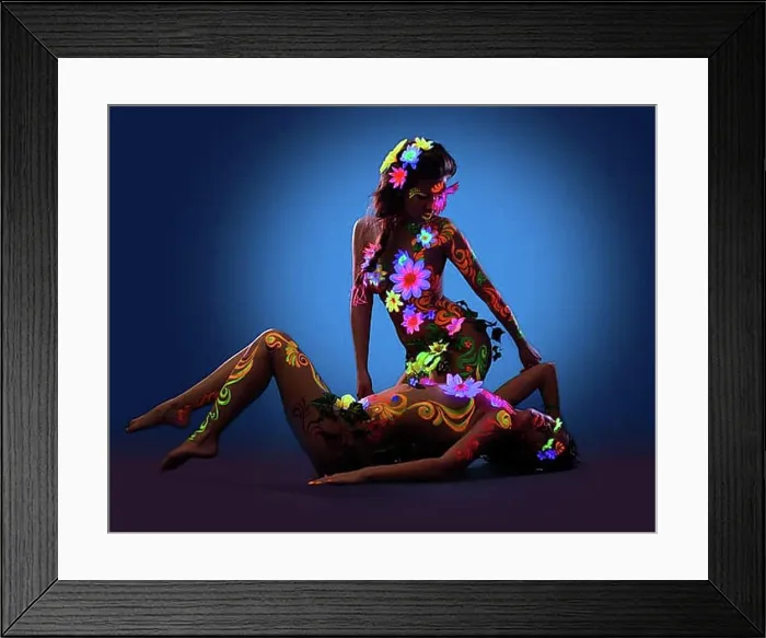 Framed Print : Couple of Naked women posing with glow ultraviolet body art and flowers