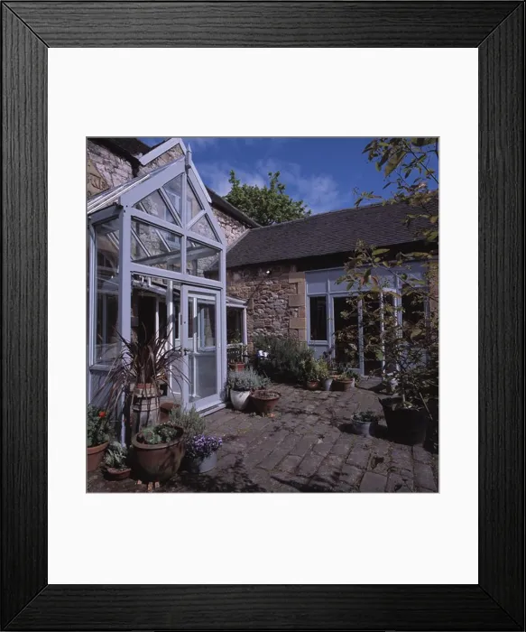 Framed Print : Modern glass porch extension on traditional house with paved courtyard Framed Print : Modern glass porch extension on traditional house with paved courtyard