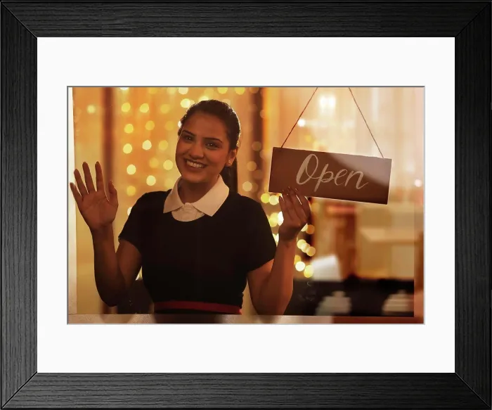 Framed Print : A YOUNG WAITRESS HAPPILY LOOKING AT CAMERA WHILE HOLDING OPEN SIGN BOARD Framed Print : A YOUNG WAITRESS HAPPILY LOOKING AT CAMERA WHILE HOLDING OPEN SIGN BOARD