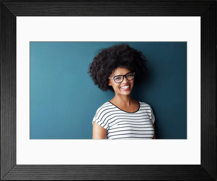 Framed Print : Black woman, portrait and smile with glasses for optometry or vision and on blue studio background