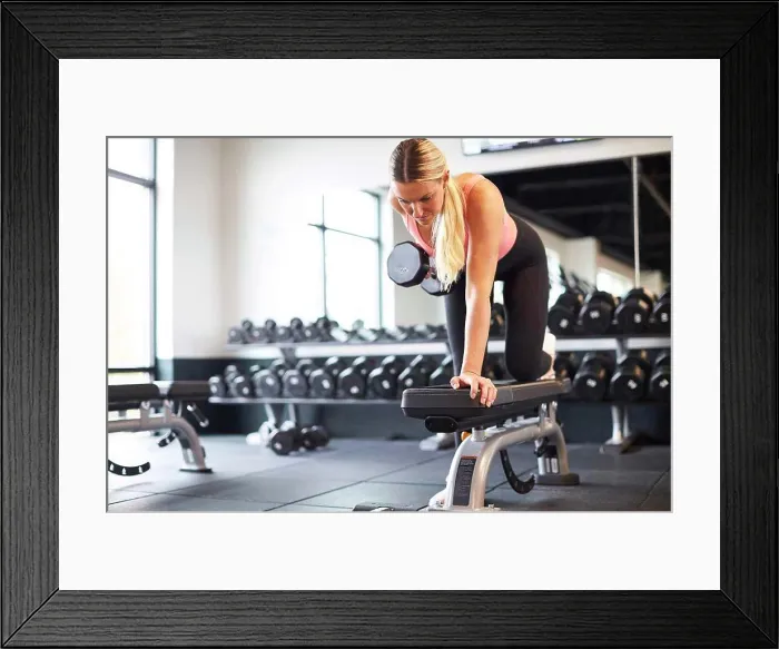 Framed Print : A blonde woman working out in a gym