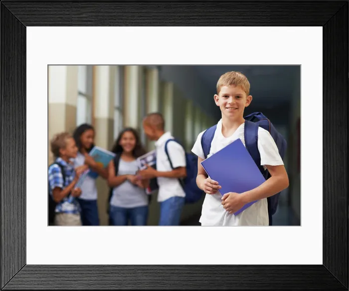 Framed Print : Boy, portrait and smile in corridor of school with backpack and books for learning Framed Print : Boy, portrait and smile in corridor of school with backpack and books for learning