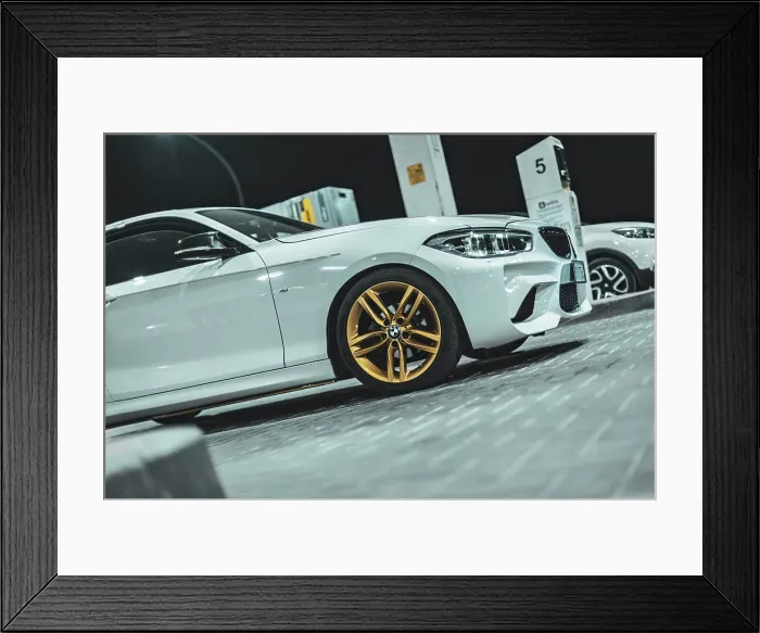 Framed Print : Adria, Italy 30 july 2024: View of a BMW Series 1 with gold wheels parked at night