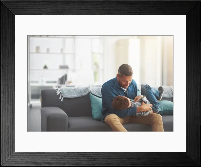 Framed Print : Father, boy and tickle kid on sofa together in home