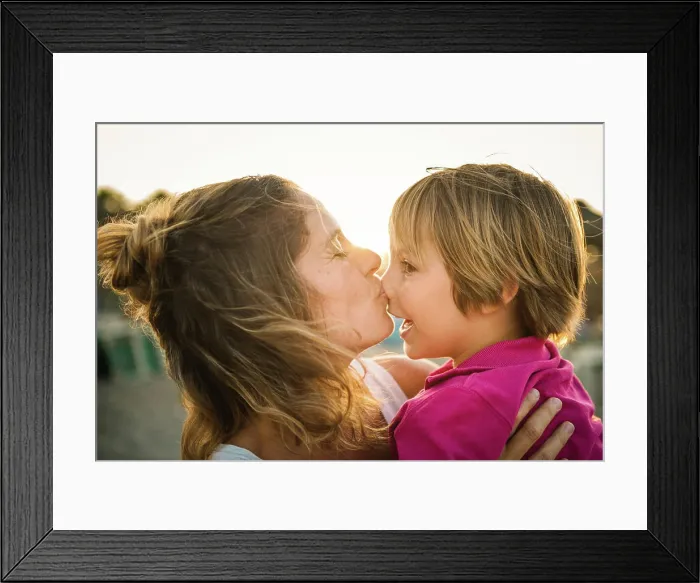 Framed Print : Side view of laughing woman carrying cheerful playful son on hands while kissing his nose on beach in sunset